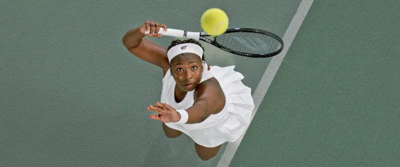 A player serving on an indoor tennis court