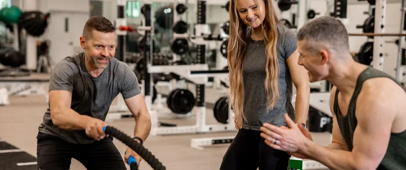 Members training with battle ropes in a Bay Club fitness centre