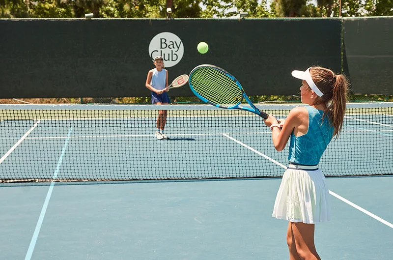 Kids playing tennis on a Bay Club court